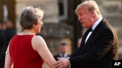
Perdana Menteri Inggris Theresa May menyambut Presiden Donald Trump sebelum jamuan makan malan di Istana Blenheim di London, 12 Juli 2018.
