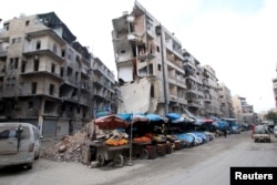 FILE - Stalls are seen on a street beside damaged buildings in the rebel held al-Shaar neighborhood of Aleppo, Syria, Feb. 10, 2016.