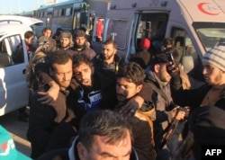A wounded Syrian, who was evacuated from rebel-held neighborhoods in the embattled city of Aleppo, is carried upon his arrival in the opposition-controlled Khan al-Aassal region, west of the city, on Dec. 15, 2016.