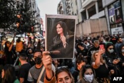 Seorang pengunjuk rasa memegang potret Mahsa Amini selama demonstrasi mendukung Amini di Istanbul pada 20 September 2022. (Foto: AFP)