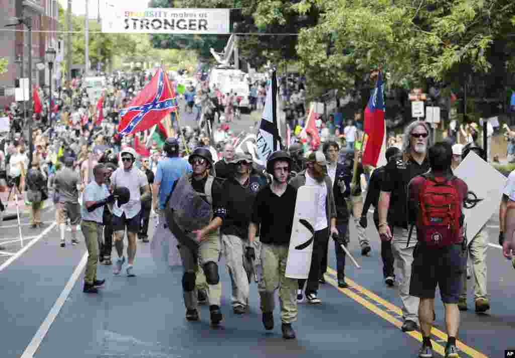 White nationalist demonstrators walk through town after their rally was declared illegal near Lee Park in Charlottesville, Va., Aug. 12, 2017.