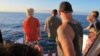 FILE - This Jan. 21, 2016, file photo shows tourists looking out on the horizon as their boat searches for dolphins in waters off Waianae, Hawaii.