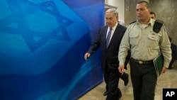 Israel's Prime Minister Benjamin Netanyahu, left, arrives for the weekly cabinet meeting in Jerusalem, Feb. 15, 2015. 
