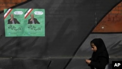 A pedestrian walks past campaign posters for parliamentary election candidate Majid Hajifaraji at Enqelab-e-Eslami (Islamic Revolution) street in downtown Tehran, Iran, Feb. 13, 2020. 