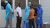 In this photo taken on March 29, 2014, medical personnel at the emergency entrance of a hospital receive suspected Ebola virus patients in Conakry, Guinea.