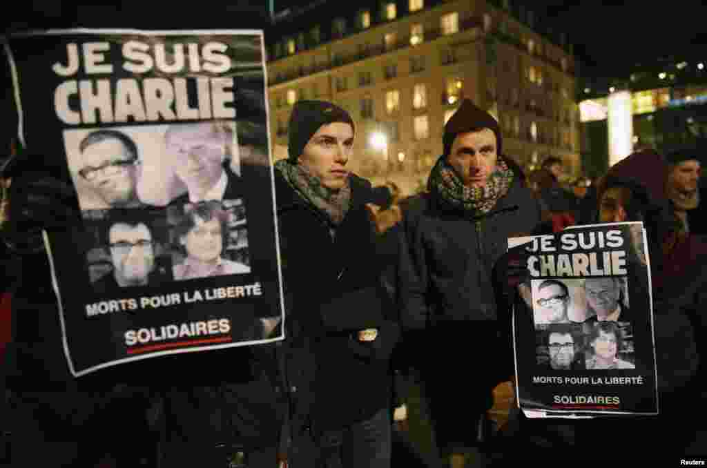 People in front of the Brandenburg Gate in Berlin hold placards that read "I am Charlie," to pay tribute to the victims of a massacre that killed more than 12 people in Paris, France, Jan. 7, 2015.