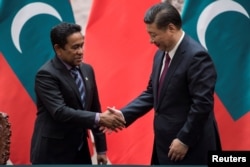 Maldives President Abdulla Yameen shakes the hand of China's President Xi Jinping after a signing meeting at the Great Hall of the People in Beijing, China, Dec. 7, 2017.
