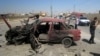 People inspect the site of a car bomb attack on cars lined up at a gas station in the oil rich city of Kirkuk, in northern Iraq, July 10, 2014. 