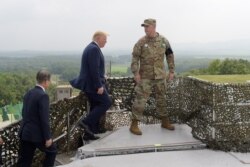 FILE - President Donald Trump and South Korean President Moon Jae-in, left, walk up to view North Korea from the Korean Demilitarized Zone from Observation Post Ouellette at Camp Bonifas in South Korea, June 30, 2019.