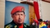 Venezuelan Vice President Nicolas Maduro raises his fist next to a painting of President Hugo Chavez during the commemoration of the 21st anniversary of Chavez's attempted coup d'etat in Caracas February 4, 2013. 