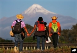 Central American migrants begin their morning trek facing Pico de Orizaba volcano as part of a thousands-strong caravan hoping to reach the U.S. border, upon departure from Cordoba, Veracruz state, Mexico, Nov. 5, 2018.