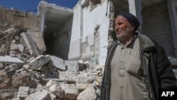 Seorang warga Suriah memeriksa puing-puing rumahnya yang hancur di Kota Ihsim di kawasan Pegunungan al-Zawiya di Provinsi Idlib, Suriah, 8 Maret 2020, menyusul kesepakatan gencatan senjata Rusia-Turki. (Foto: AFP)