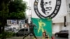 Seorang pria duduk di sebelah patung Pele, bintang sepak bola Brazil di Santos, Brazil, Jumat, 30 Desember 2022. Pele meninggal dunia di São Paulo pada usia 82 tahun, 29 Desember 2022. (AP/Matias Delacroix)