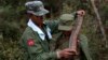 FILE - A rebel soldier of Myanmar National Democratic Alliance Army places a machine gun bullet belt around the neck of another soldier at a military base in Kokang region, March 10, 2015. 