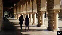FILE - Students walk on the Stanford University campus, March 14, 2019, in Santa Clara, Calif.