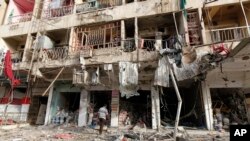Seorang pria memeriksa lokasi ledakan bom mobil di Baghdad, 8 Juni 2014. 
