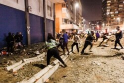 FILE - South Africa Police Services (SAPS) officers stop looters from looting in central Durban, July 11, 2021.
