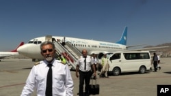 Sekelompok pilot dari maskapai Ariana Afghan tampak berjalan di area Bandara Internasional Hamid Karzai di Kabul, Afghanistan, setelah mendarat pada 5 September 2021. (Foto: AP)