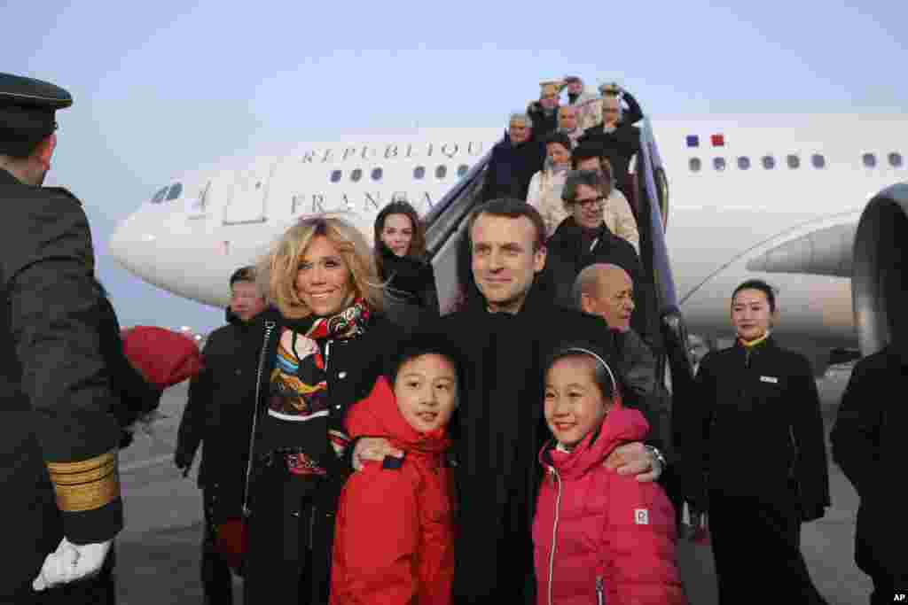 2018年1月8日,法国总统马克龙(Emmanuel Macron)和夫人布丽吉特·马克龙(Brigitte Macron)在北京首都机场的停机坪和参加欢迎仪式的中国儿童合影。
