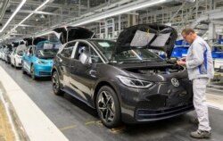 FILE PHOTO: An employee works at a production line of the electric Volkswagen model ID.3 in Zwickau, Germany, February 25, 2020. REUTERS/Matthias Rietschel/File Photo GLOBAL BUSINESS WEEK AHEAD