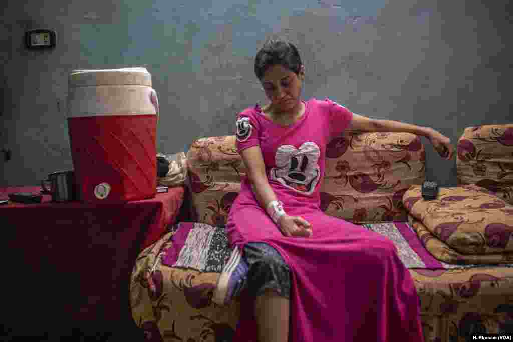 Christen Nabil, a resident of Cairo’s “Garbage City,” lives with a needle in her arm to deliver medication and nutrients. She was diagnosed with intestinal inflammation, which she attributes to poor food quality.
