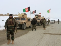 FILE - Afghan National Army forces are seen near the site of an airplane crash in Deh Yak district of Ghazni province, Afghanistan, Jan. 27, 2020.