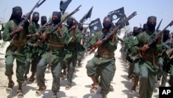 FILE - Al-Shabab fighters march with their weapons during military exercises on the outskirts of Mogadishu, Somalia, Feb. 17, 2011. Missiles fired Feb. 21, 2018, targeted a rickshaw carrying al-Shabab militants near Jamaame, in the southern Lower Juba region, causing several deaths, officials said.