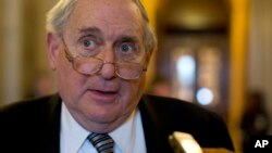 FILE - Now retired senator Carl Levin is seen speaking with reporters on Capitol Hill in Washington, Feb. 26, 2013. He says public anger over the Panama Papers offers an opportunity to "make real progress" in ending financial abuses.