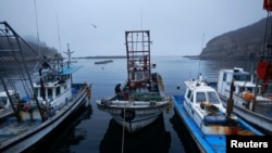 FILE - A fisherman sits on his boat in a small port on the island of Baengnyeong, which lies on the South Korean side of the Northern Limit Line, in the Yellow Sea, April 11, 2014.