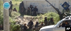 FILE - This image posted on the Twitter page of Syria's al-Qaida-linked Nusra Front, April 25, 2015, shows Nusra Front fighters in the town of Jisr al-Shughour, Idlib province, Syria.