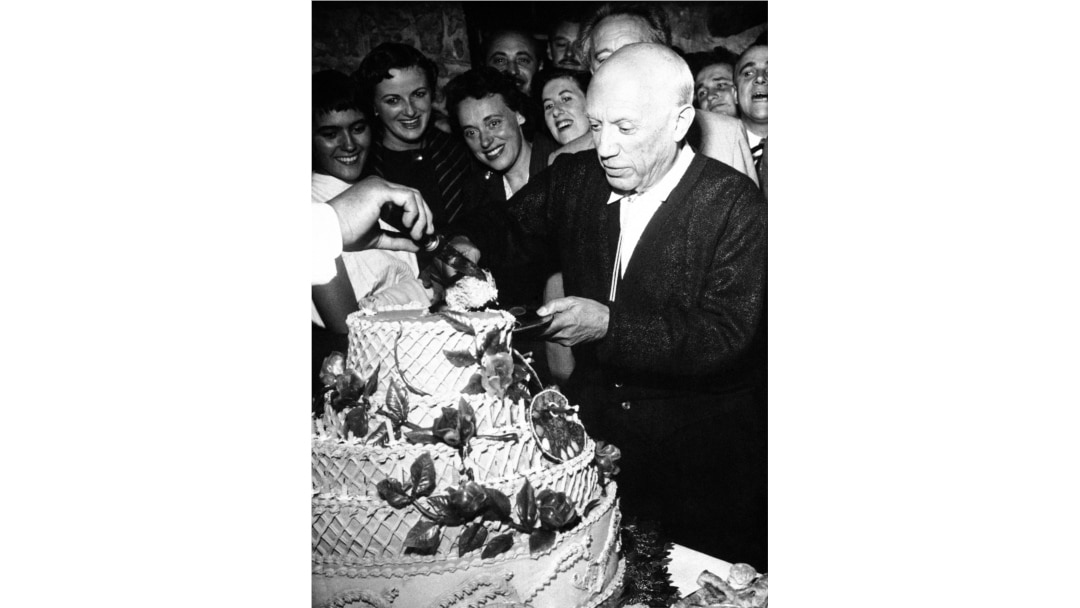 Pablo Picasso, famed Spanish painter, accepts first piece of 67-pound birthday cake as he celebrates his 75th birthday, with a birthday party at Vallauris in southern France on Oct. 24, 1956.