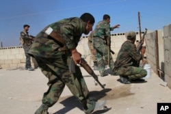 Syrian soldiers fire to repel an attack in Achan, Hama province, Oct. 11, 2015.