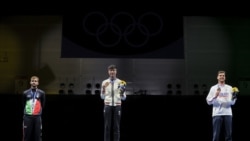 香港劍擊選手張家朗（圖中）2021年7月26日在東京奧運會上奪得男子花劍個人賽金牌後，與銀牌和銅牌得主分別站在頒獎台上 （路透社照片）