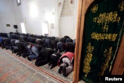FILE - Muslim Tatar men pray in the Great Khan mosque (Khan Dzhami) in the Crimean town of Bakhchisaray, March 13, 2015.
