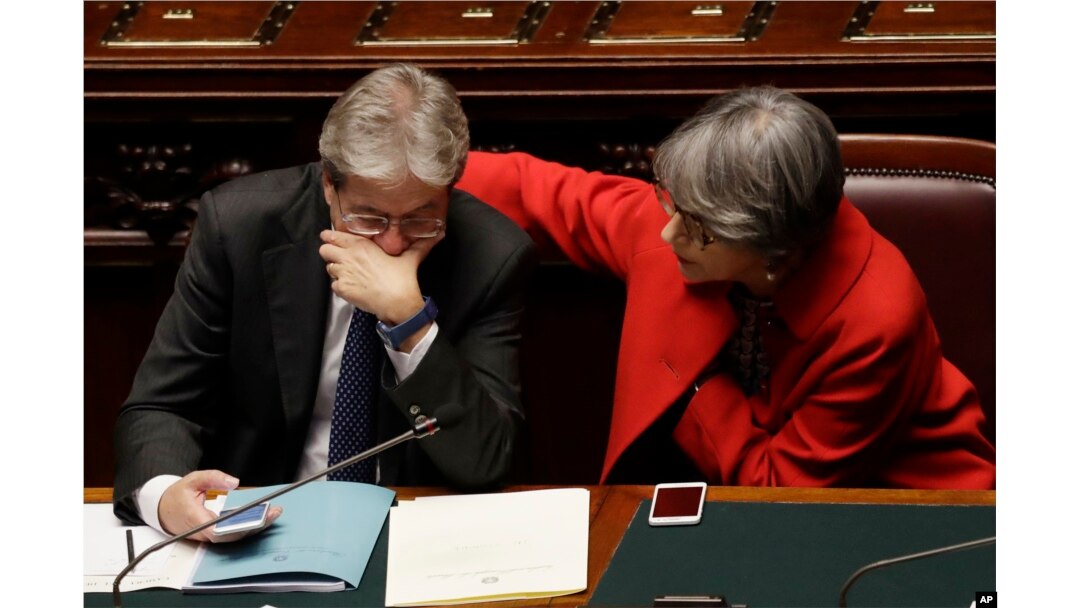 Italian Prime Minister Paolo Gentiloni talks with his Minister of Relations Anna Finocchiaro after giving his first speech as prime minister, Tuesday, Dec. 13, 2016.