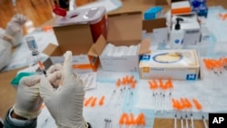 In this April 8, 2021, file photo, a Northwell Health registered nurses fills a syringe with the Johnson & Johnson COVID-19 vaccine at a pop up vaccination site at the Albanian Islamic Cultural Center in the Staten Island borough of New York. 