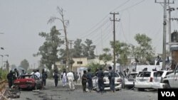 Petugas keamanan Afghanistan memeriksa lokasi ledakan di provinsi Helmand, hari Sabtu (27/8).
