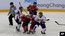 South Korea, wearing white uniforms, and North Korean players compete during their IIHF Ice Hockey Women's World Championship Division II Group A game in Gangneung, South Korea, April 6, 2017. 