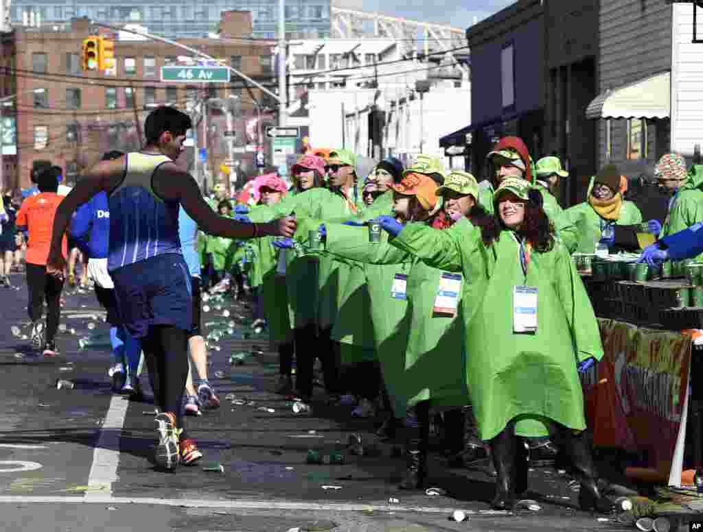 A runner pauses to grab water as he runs down Vernon Blvd. in Long Island City in the Queens borough of New York during the New York City Marathon on Nov. 2, 2014, in New York.