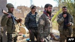 Para pejuang SDF (Pasukan Demokrat Suriah) yang didukung AS, memeriksa kamp sementara bagi anggota ISIS dan keluar mereka di kota Baghouz, Suriah timur laut, 9 Maret 2019. (Foto: dok).