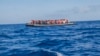 A rubber boat with 129 migrants on board, among them 60 women, is seen sailing out of control about 15 miles north of Al Khums, Libya, Aug. 1, 2017.