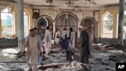 Warga memeriksa kerusakan di dalam masjid di Kunduz, Afghanistan, setelah serangan bom berlangsung saat sholat Jumat (8/10).