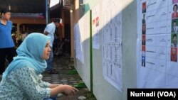 FILE - Seorang pemilih memeriksa daftar legislatif yang dipasang di sebuah TPS di Sleman, DIY dalam Pemilu 2019. (Foto: VOA/ Nurhadi)