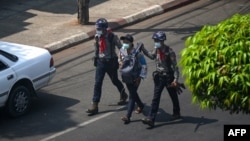 Dua polisi menahan seorang jurnalis "Myanmar Now" di Yangon, di tengah maraknya demonstrasi anti rezim militer di negara itu (foto: dok). 