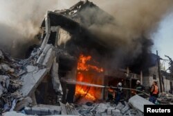 Petugas memadamkan api di sebuah rumah setelah serangan Israel, di tengah konflik yang sedang berlangsung antara Israel dan Hamas, di Khan Younis di selatan Jalur Gaza, 9 Desember 2023. (Foto: REUTERS/Ibraheem Abu Mustafa)