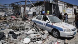 FILE - Debris covers the ground and an emergency vehicle after an airstrike at a detention center in Tajoura, east of Tripoli in Libya, July 3, 2019.