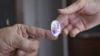 A poll worker hands a sticker to a voter on Super Tuesday in Stillwater, Okla., March 1, 2016.