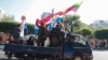 Supporters onboard a car wave national and military flags Tuesday, Feb. 2, 2021, in Yangon, Myanmar. Hundreds of members of Myanmar's Parliament remained confined inside their government housing in the country's capital on Tuesday, a day after the militar