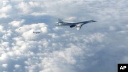 FILE - In this image made available by the Royal Air Force, Jan. 15, 2018, two Russian Blackjack Tupolev Tu-160 long-range bombers are followed by an RAF Typhoon aircraft (L) scrambled from RAF Lossiemouth, Scotland.