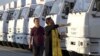 A Russian Orthodox Church clergyman blesses a convoy of white trucks with humanitarian aid in Alabino, outside Moscow Tuesday, Aug. 12, 2014